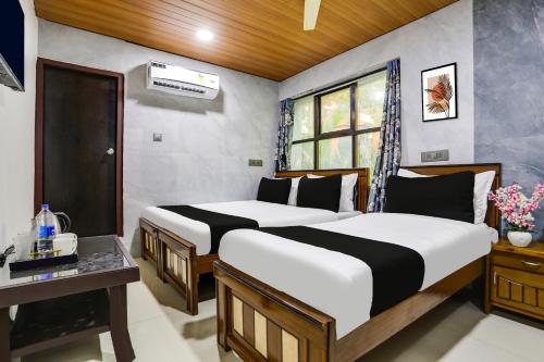 - une chambre avec 2 lits, un bureau et une fenêtre dans l'établissement Super Hotel O Madhapur VIP Hills, à Hyderabad