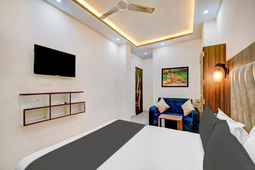 Super Townhouse Anisabad Near Mahavir Sansthan في Khagaul: غرفة نوم بسرير وتلفزيون وكرسي