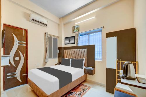 Super Townhouse Anisabad Near Mahavir Sansthan في Khagaul: غرفة نوم بسرير ومكتب وتلفزيون