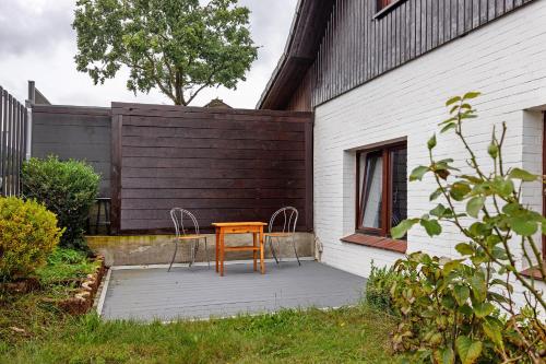 een houten tafel en 2 stoelen op een patio bij Gemütliche Wohnung Buchholz i d N in Buchholz in der Nordheide