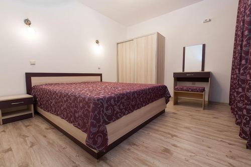 a bedroom with a bed and a mirror in it at Family Hotel Relaxa in Sapareva Banya