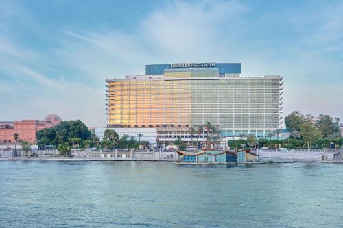 um grande edifício ao lado de uma massa de água em The Nile Ritz-Carlton, Cairo em Cairo