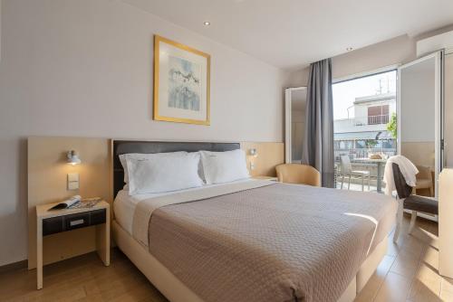 um quarto de hotel com uma cama e uma varanda em Piraeus City Hotel em Pireu