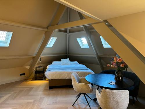 - une chambre mansardée avec un lit et une table dans l'établissement Breda City Apartments, à Breda