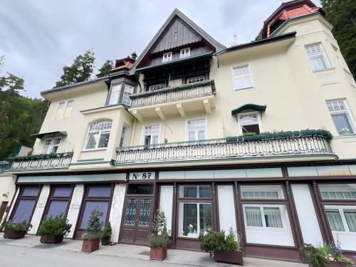 duży biały budynek z balkonem na górze w obiekcie Villa AlexanderCharmante Wohnung mit Bergblick, Villa Alexander w mieście Semmering