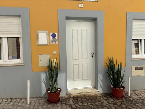 uma porta branca num edifício com duas plantas em La petite maison em Portimão