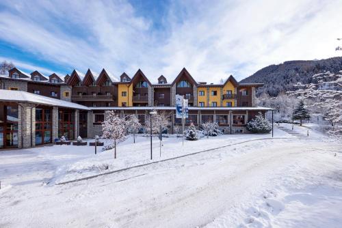 un grand lodge dans la neige recouverte de neige dans l'établissement Blu Hotel Acquaseria, à Ponte di Legno