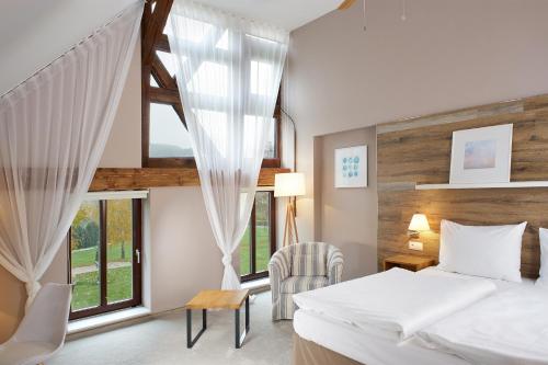 um quarto com uma cama e uma grande janela em Cihelny Golf & Wellness Resort em Karlovy Vary