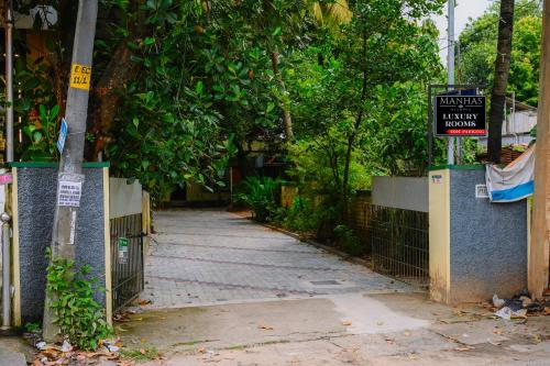 einen Bürgersteig mit einem Zaun und einem Schild darauf in der Unterkunft Manhas Olympus in Ernakulam