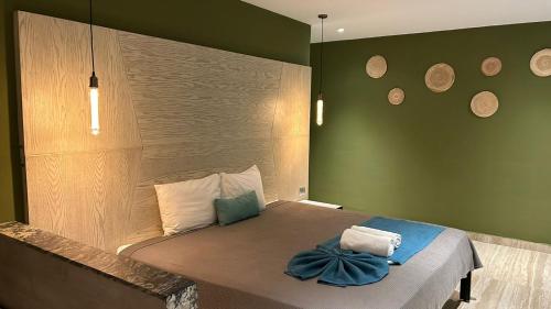 um quarto com uma cama com uma parede verde em LOL-HA Hotel Boutique em Cancún