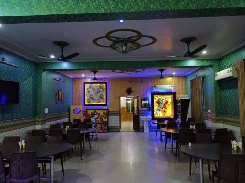 a dining room with tables and chairs and a television at MAAN Hotel in Alwar