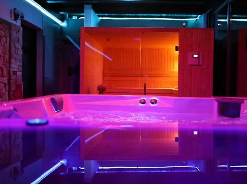 a pink bath tub in a room with purple lights at Hanu lui Gica Spa in Satu Mare