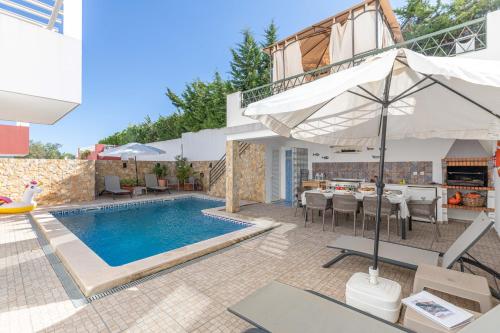 a villa with a swimming pool and a patio at Tavira Casa Jenny in Tavira