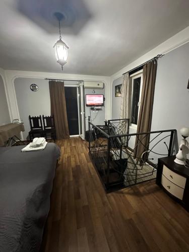 a bedroom with a bed and a dining room with a television at Apartment Lui in Tbilisi City