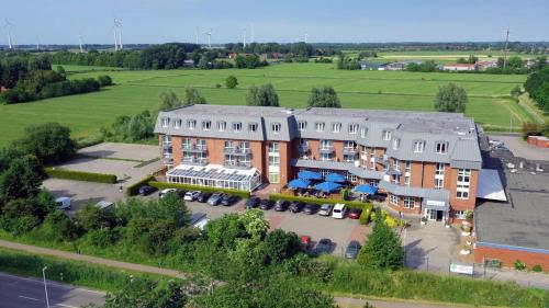 une vue aérienne sur un bâtiment avec un parking dans l'établissement Hotel Novum, à Hinte