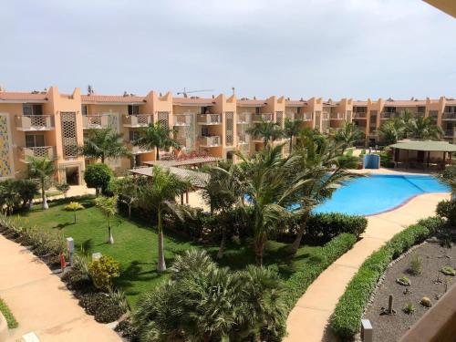 - une vue aérienne sur un complexe avec une piscine et des palmiers dans l'établissement Tropical Morabeza Apartment Santa Maria, à Santa Maria