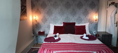 una camera da letto con un grande letto con cuscini rossi di Bed and Breakfast Raapop ad Arnhem