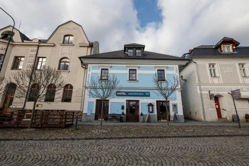 eine Gruppe von Gebäuden auf der Straßenseite in der Unterkunft Hotel Modrásek in Kašperské Hory