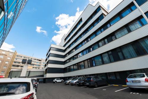 un grande edificio con auto parcheggiate in un parcheggio di Post 120 Suites a Praga