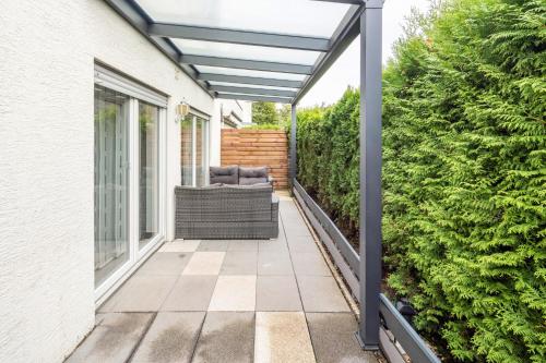 pérgola sobre un patio con una silla en el porche en Ferienwohnung Jasmin, en Leonberg