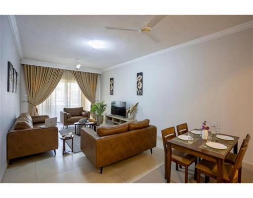 sala de estar con sofá, mesa y sillas en Marjaan Apartments, en Mombasa