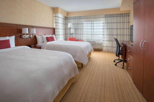 um quarto de hotel com duas camas e uma secretária em Courtyard Boston-South Boston em Boston