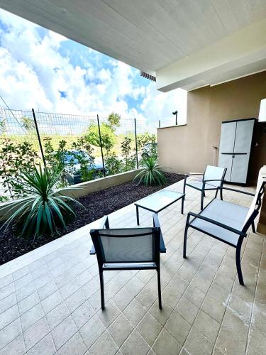 a group of chairs and tables on a patio at Suites Dreams Fiumicino River in Fiumicino