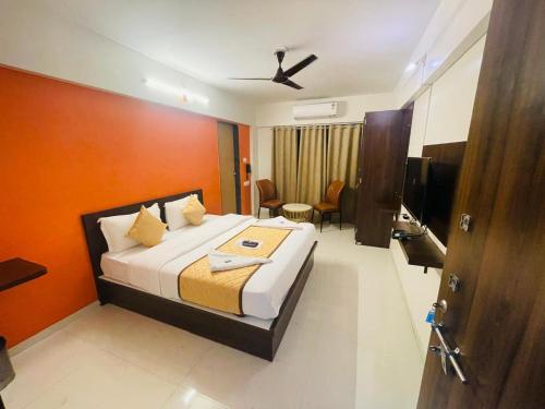 um quarto com uma cama com uma parede laranja em Habitat Inn em Pune