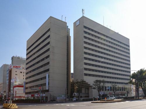 een groot grijs gebouw met een kruis erop bij SK HOTEL Kobe Ekimae in Kobe