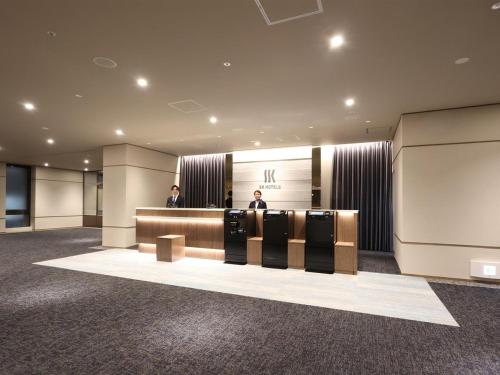 een lobby met twee mannen aan een balie bij SK HOTEL Kobe Ekimae in Kobe