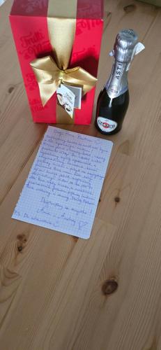 eine Flasche Bier neben einer Geschenkbox und einen Zettel in der Unterkunft Apartamenty STARA PIEKARNIA in Płock