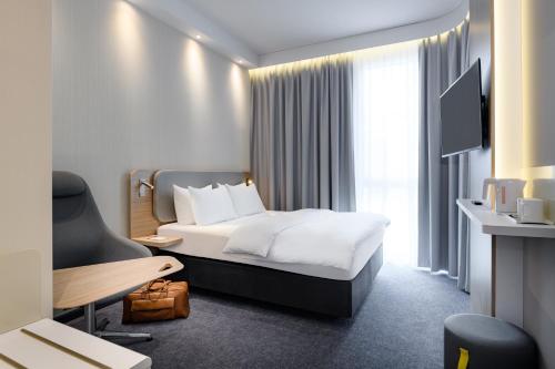 ein Hotelzimmer mit einem Bett und einem TV in der Unterkunft Holiday Inn Express Munich Airport - Erding, an IHG Hotel in Erding