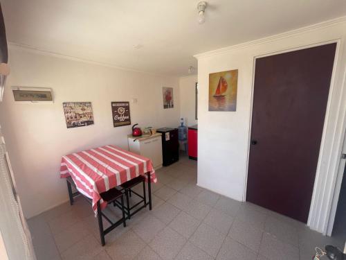 um quarto com uma mesa e uma cozinha com um frigorífico em Cabañas La Herradura em Coquimbo