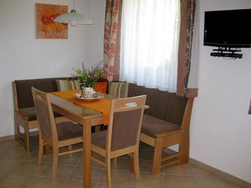 mesa de comedor con sillas y TV en Apartment Galtenberg, en Alpbach