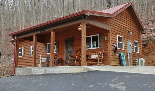 eine große Holzhütte mit einer Veranda in der Unterkunft Couple Retreat Cabin-near Smoky Mountain Railroad-Hot Tub in Bryson City