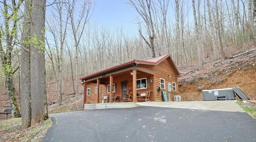 eine kleine Holzhütte inmitten eines Waldes in der Unterkunft Couple Retreat Cabin-near Smoky Mountain Railroad-Hot Tub in Bryson City