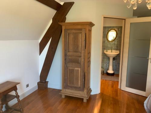 a room with a wooden cabinet and a sink at Longue Vue en Arbois in Arbois