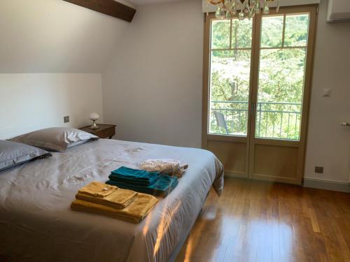 a bedroom with a bed with two towels on it at Longue Vue en Arbois in Arbois