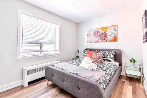 een slaapkamer met een bed en een raam bij Corktown Hamilton - Modern Apartment in Hamilton