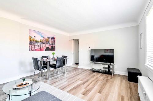 een woonkamer met een tafel en een televisie bij Corktown Hamilton - Modern Apartment in Hamilton