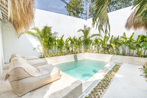 - une piscine au milieu d'une terrasse avec un canapé dans l'établissement The Stay Padang Padang, à Bingin Beach