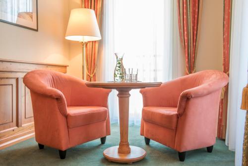 twee oranje stoelen en een tafel in een kamer bij Hotel Vitalquelle Montafon in Schruns