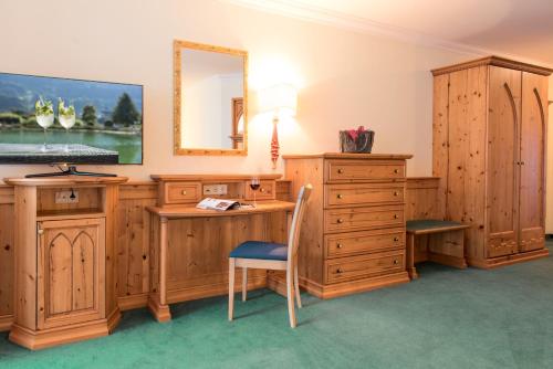 een kamer met een bureau en een spiegel bij Hotel Vitalquelle Montafon in Schruns