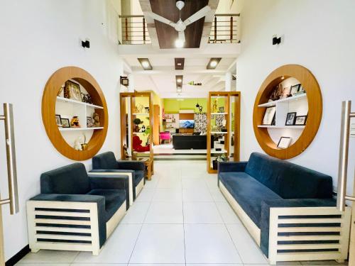 einen Salon mit blauen Sofas und Spiegeln in der Unterkunft Thottungal Homestay in Ernakulam