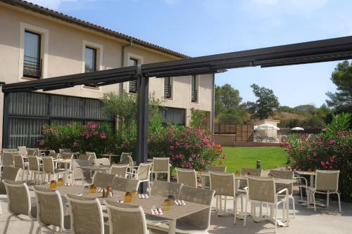 a group of tables and chairs on a patio at Grand Prix Hôtel & Restaurant in Le Castellet