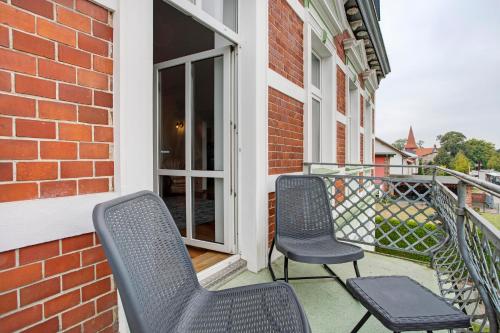 two chairs on the balcony of a brick building at Inselglück in Altefähr