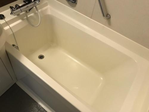 eine weiße Badewanne im Bad in der Unterkunft Hotel Sunroute Sopra Kobe in Kōbe