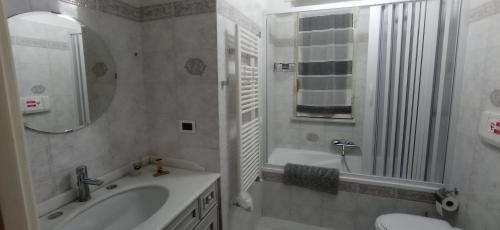 a bathroom with a sink and a toilet and a mirror at Casa Melo in Ciampino