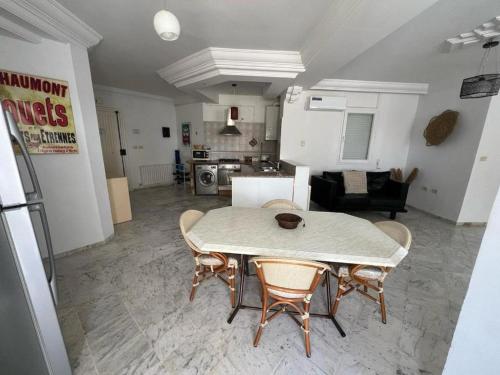 Il comprend un salon avec une table et des chaises ainsi qu'une cuisine. dans l'établissement SousseCozy apartment Chatt Meriem, à Hammam Sousse