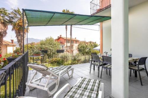 een patio met stoelen en tafels op een balkon bij Appartamento Gino in Cannero Riviera